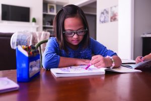 Girl with Down syndrome reading a book.