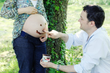 Father putting Nutella on a pregnant belly